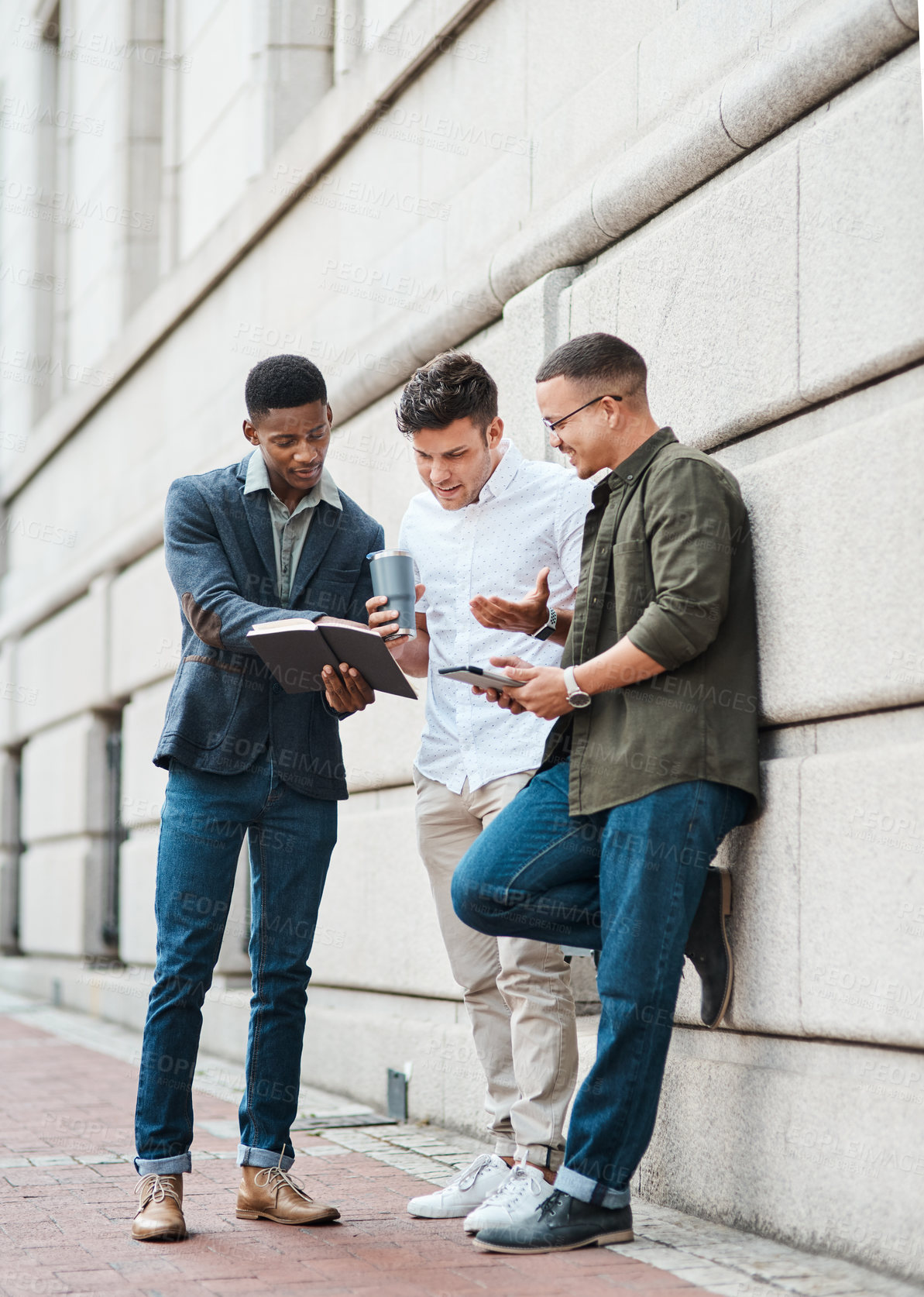 Buy stock photo Shot of a group young businessmen using a digital tablet together against an urban background