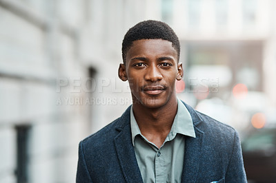 Buy stock photo Portrait of a confident young businessman standing against an urban background