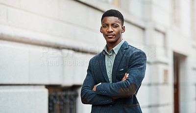 Buy stock photo Portrait of a confident young businessman standing against an urban background