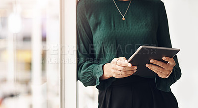 Buy stock photo Cropped portrait of an unrecognizable young businesswoman using her tablet while standing in the office