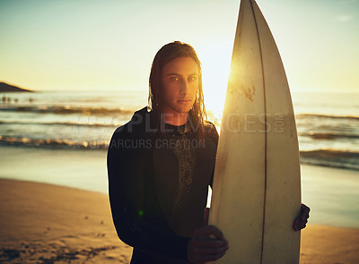 Buy stock photo Portrait of a young man standing with a surfboard at the beach