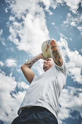 Buy stock photo Low angle shot of a focused young rugby player about to throw the ball at his team mates at a line out during a match outside on a field