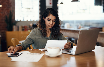 Buy stock photo Young businesswoman, entrepreneur and coffee shop owner looking overwhelmed going through paperwork. Serious and concerned female cafe manager going through or reading logistics sheet for the month.