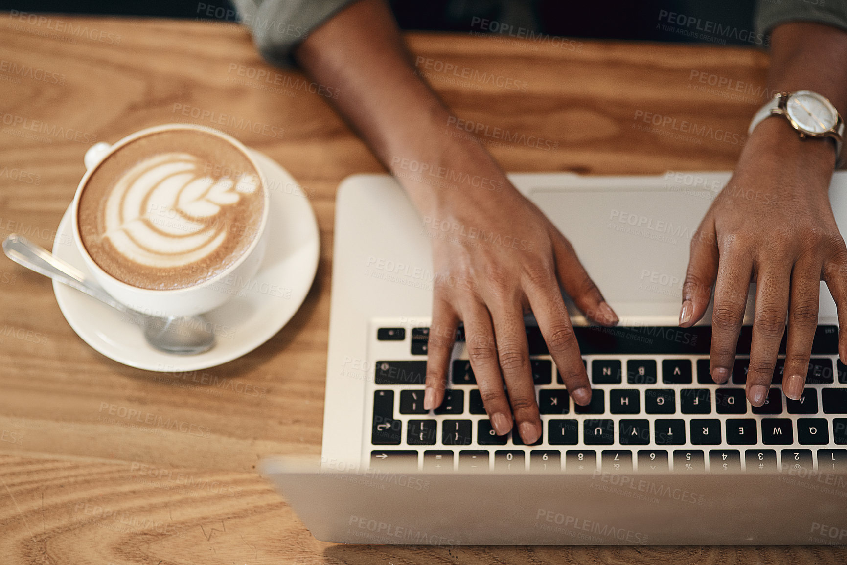 Buy stock photo High angle shot of an unrecognisable woman using a laptop and having coffee in a cafe
