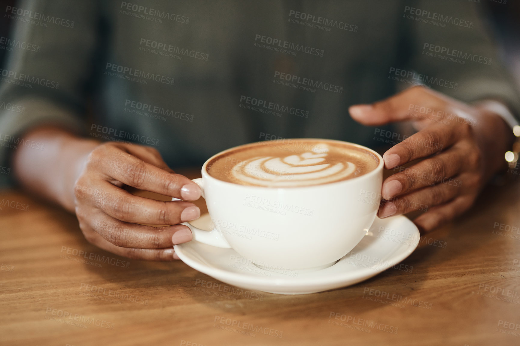 Buy stock photo Woman drinking coffee, sitting and relaxing in a cafe. Close up of an African lady with cappuccino, holding a cup at a restaurant table. Enjoying a hot beverage while on a break, taking time for rest