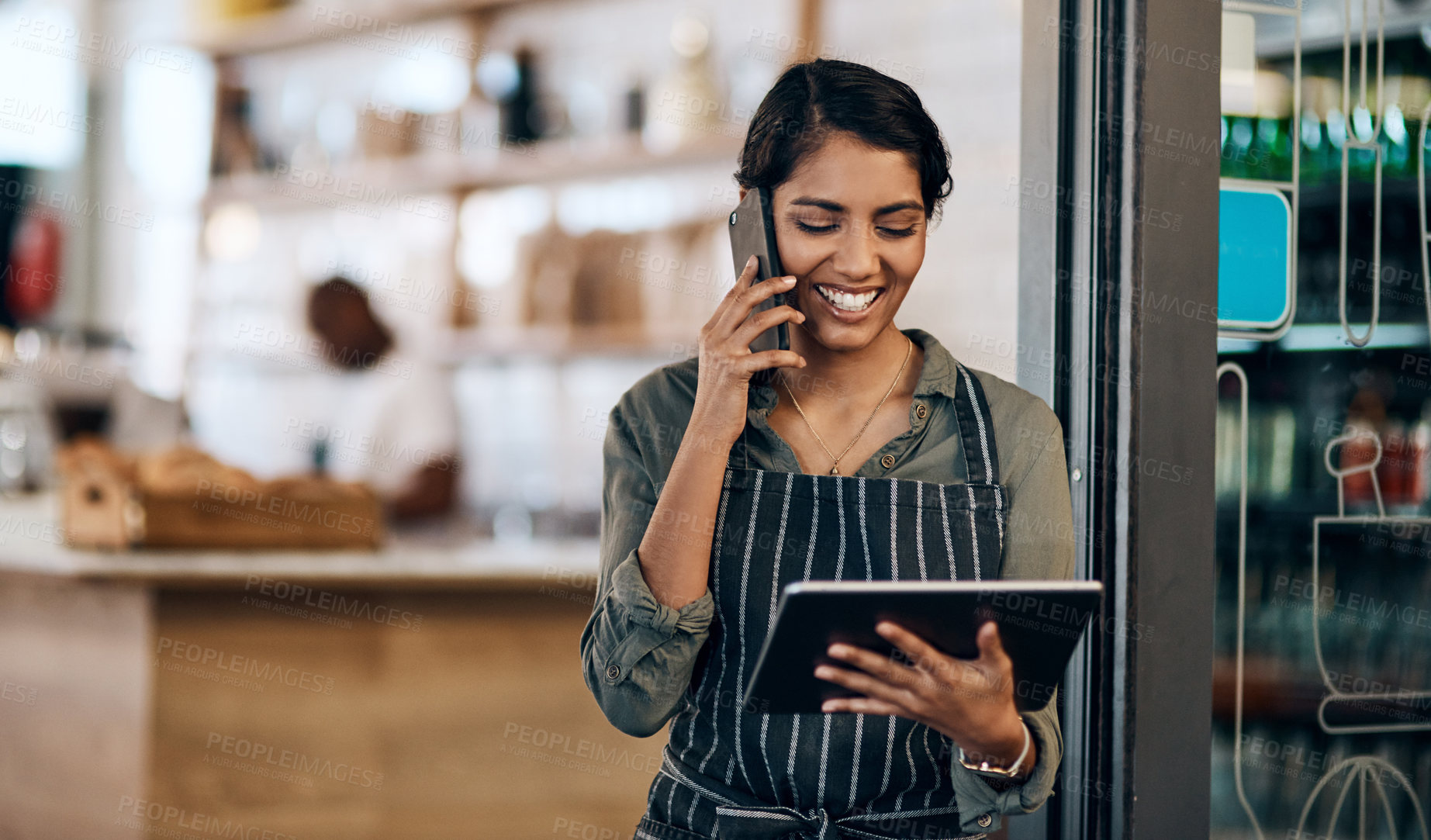 Buy stock photo Shot of a young woman using a digital tablet and smartphone while working in cafe