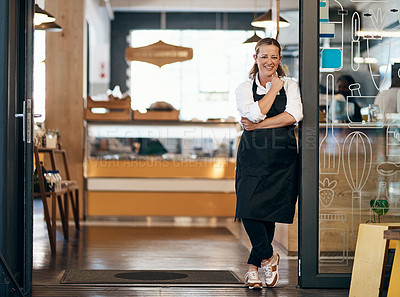 Buy stock photo Portrait of a confident mature woman standing at the entrance of her cafe