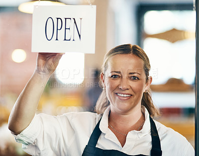 Buy stock photo Cafe owner opening her new startup, store or welcoming customers to a restaurant. Caucasian manager reopening her business after closing down. Waitress holding open sign at window or entrance.

