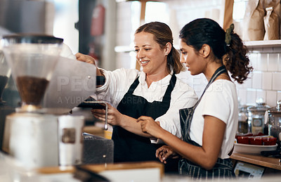 Buy stock photo Shot of two women preparing coffee in a cafe