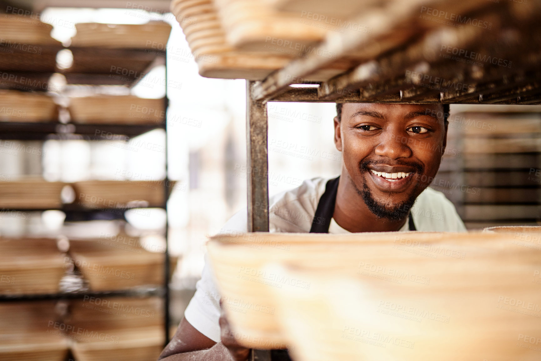 Buy stock photo Cropped shot of a male baker pushing a baking trolley