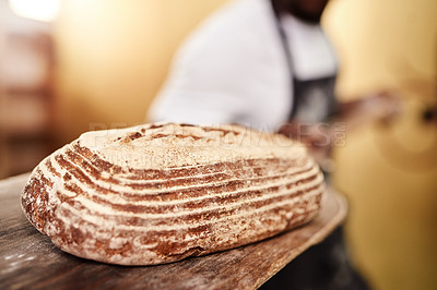 Buy stock photo Cropped shot of a male baker removing freshly baked bread from the oven