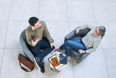 Buy stock photo High angle shot of two businesspeople having a discussion in an office