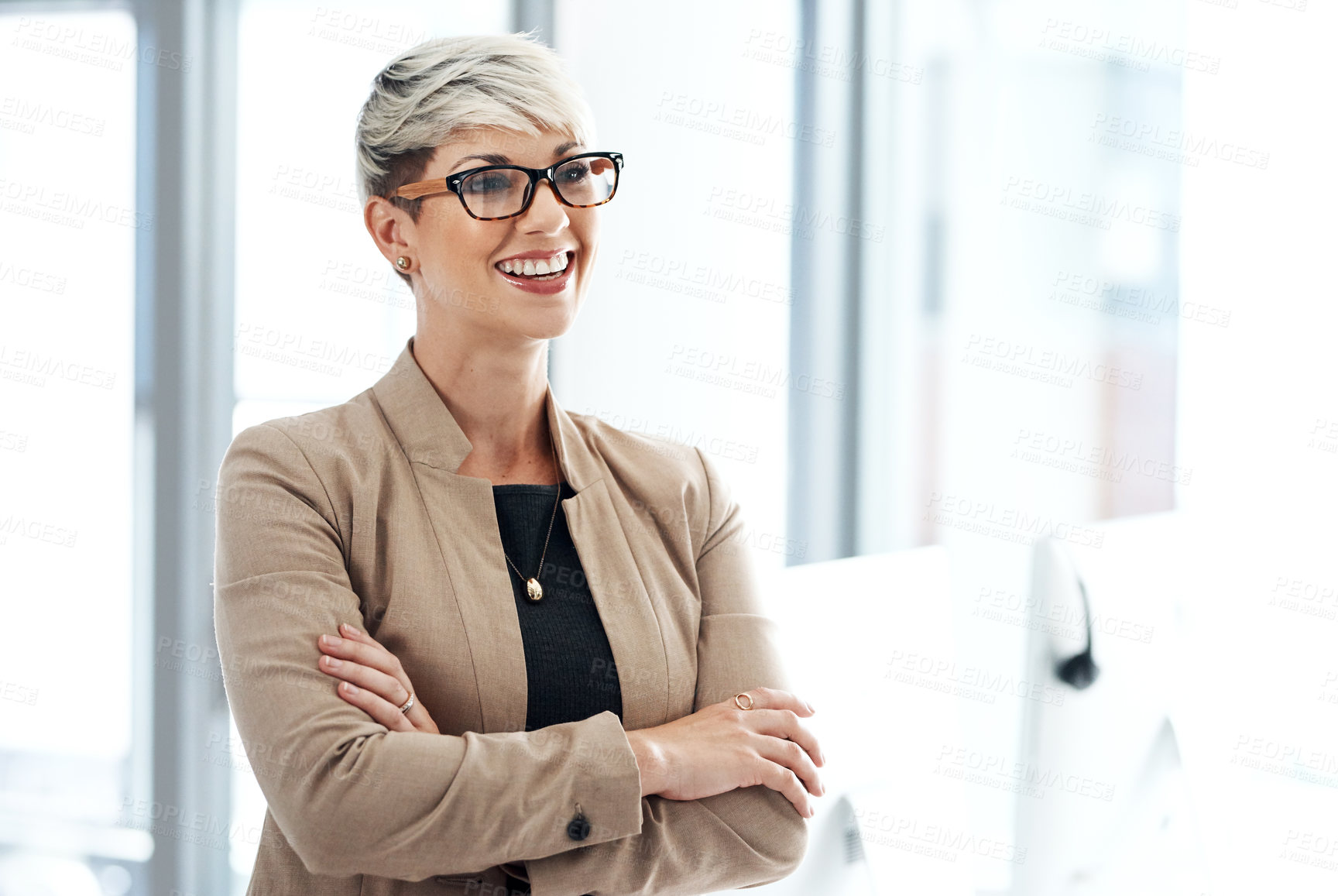Buy stock photo Shot of a young businesswoman standing with her arms crossed in an office