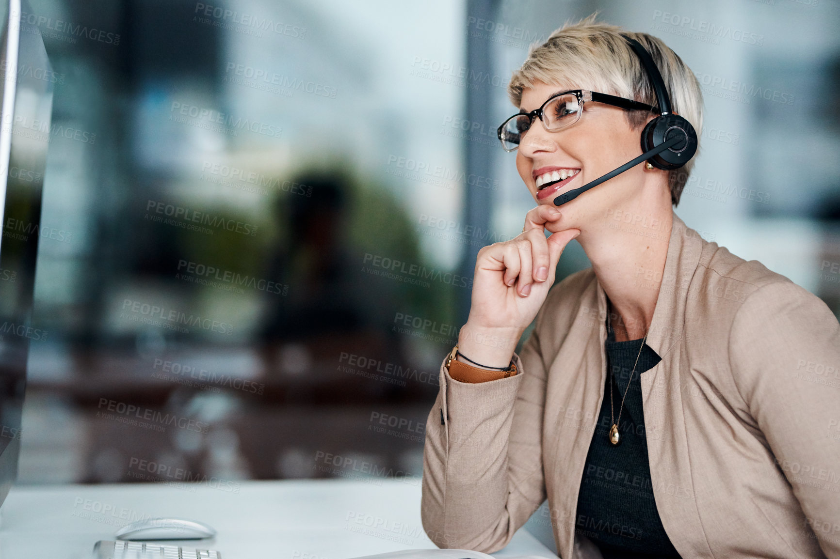 Buy stock photo Shot of a young businesswoman wearing a headset while working on a computer in an office