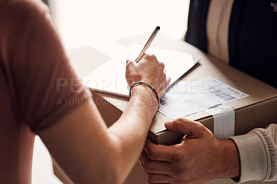 Buy stock photo Closeup shot of an unrecognisable woman using a digital tablet to sign for a delivery from the courier