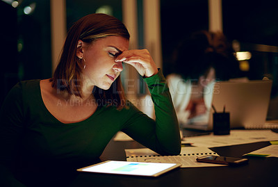 Buy stock photo Shot of a businesswoman suffering with a headache while working late