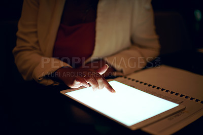 Buy stock photo Shot of an unrecognisable businesswoman using a digital tablet in an office at night