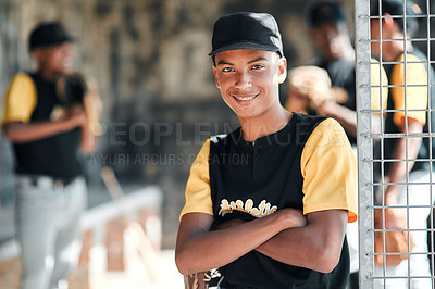 Buy stock photo Portrait of a young baseball player standing with his arms crossed with his teammates standing in the background
