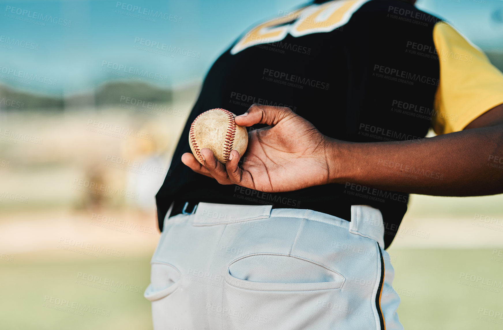 Buy stock photo Rearview shot of a baseball player holding the ball behind his back