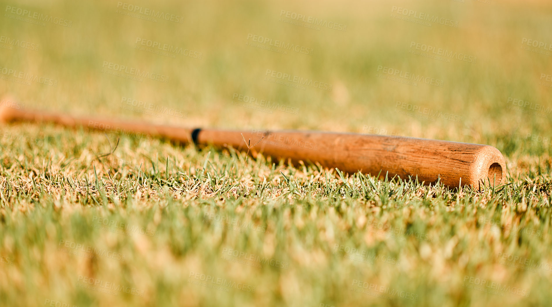 Buy stock photo Shot of a baseball bat lying on a field