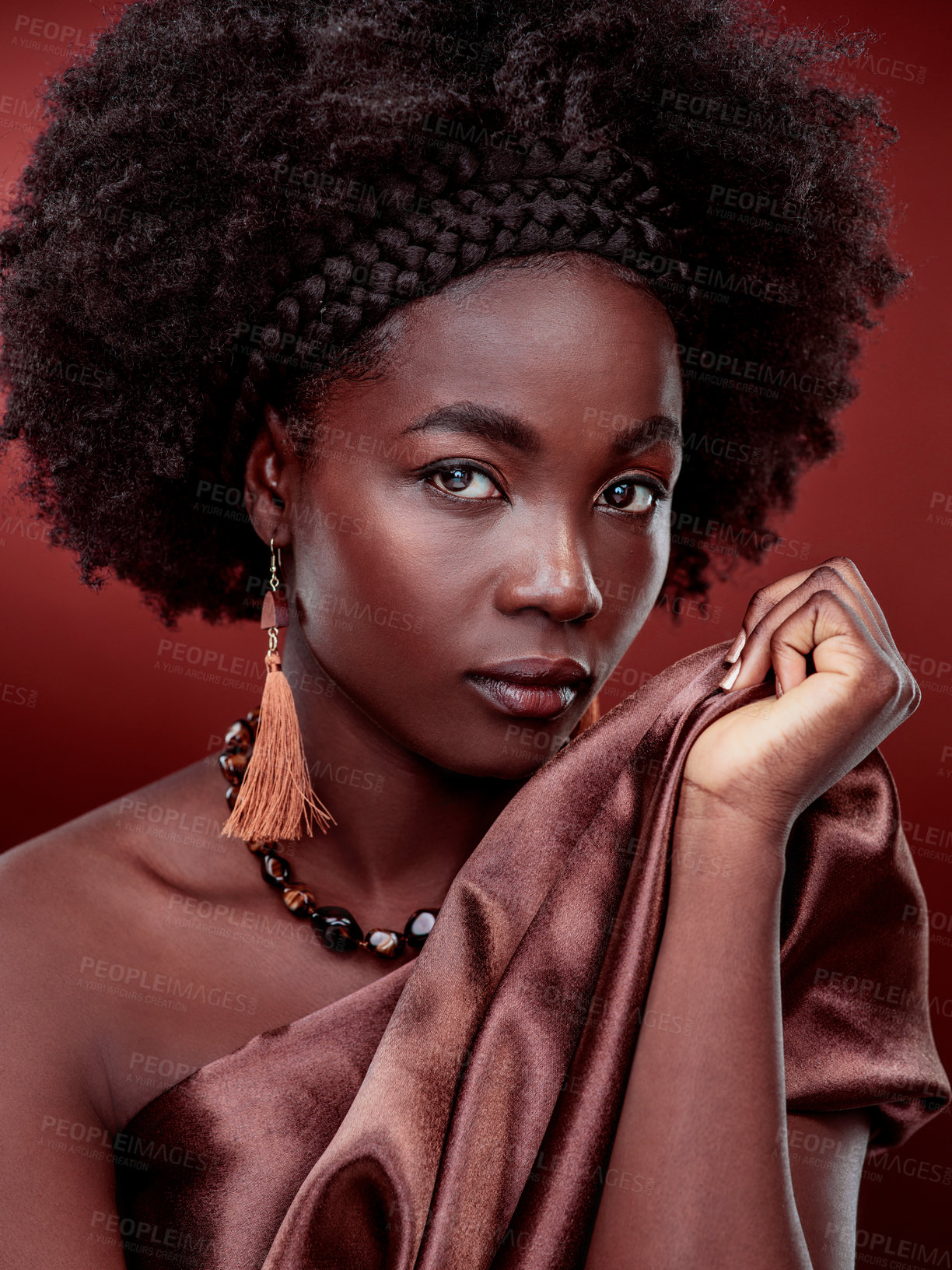 Buy stock photo Cropped portrait of a beautiful young woman posing against a red background