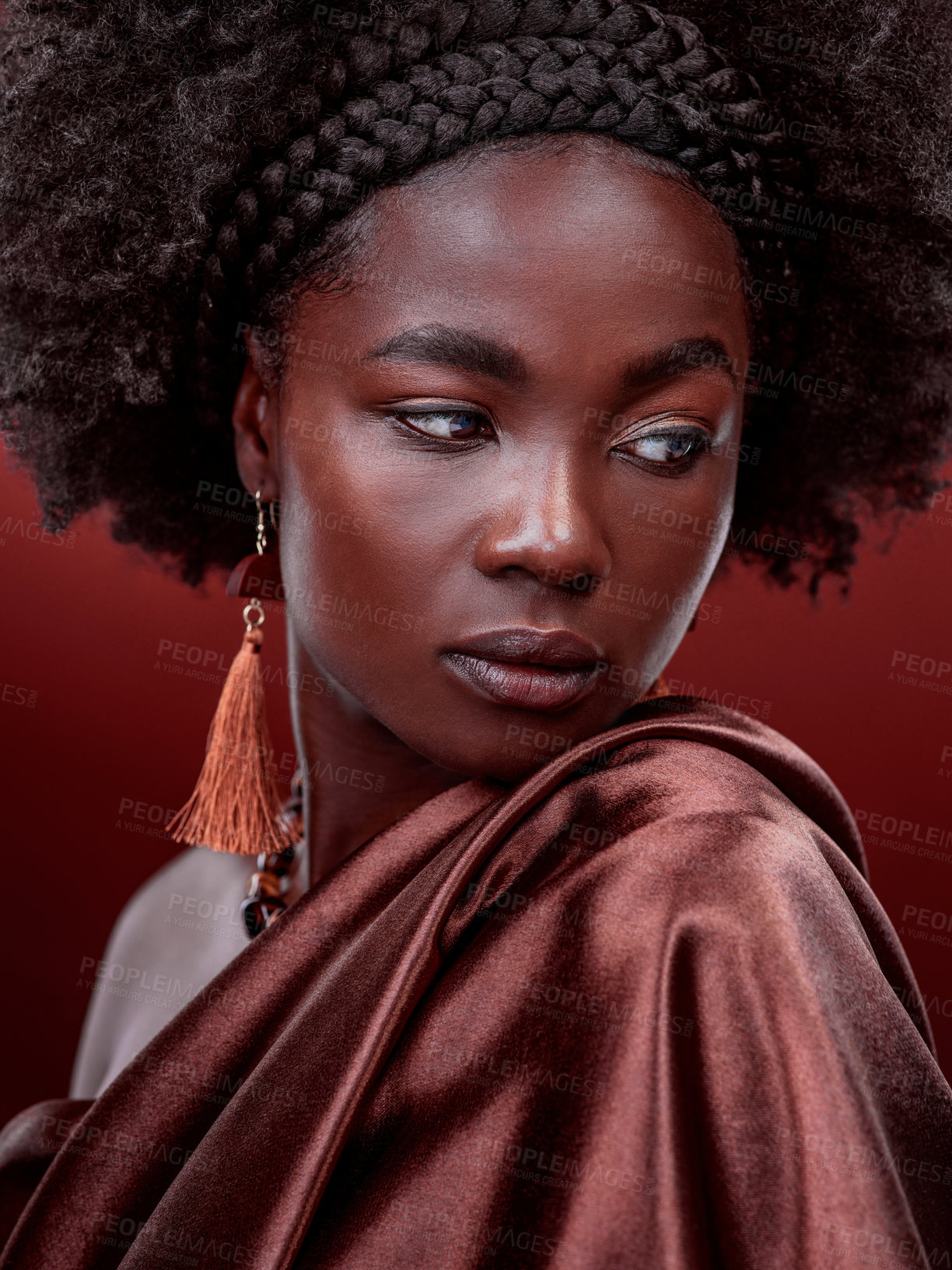 Buy stock photo Natural beauty, idea and black woman with fashion in studio isolated on a red background. Aesthetic, makeup cosmetics and African female model with stylish outfit, traditional jewelry and culture.