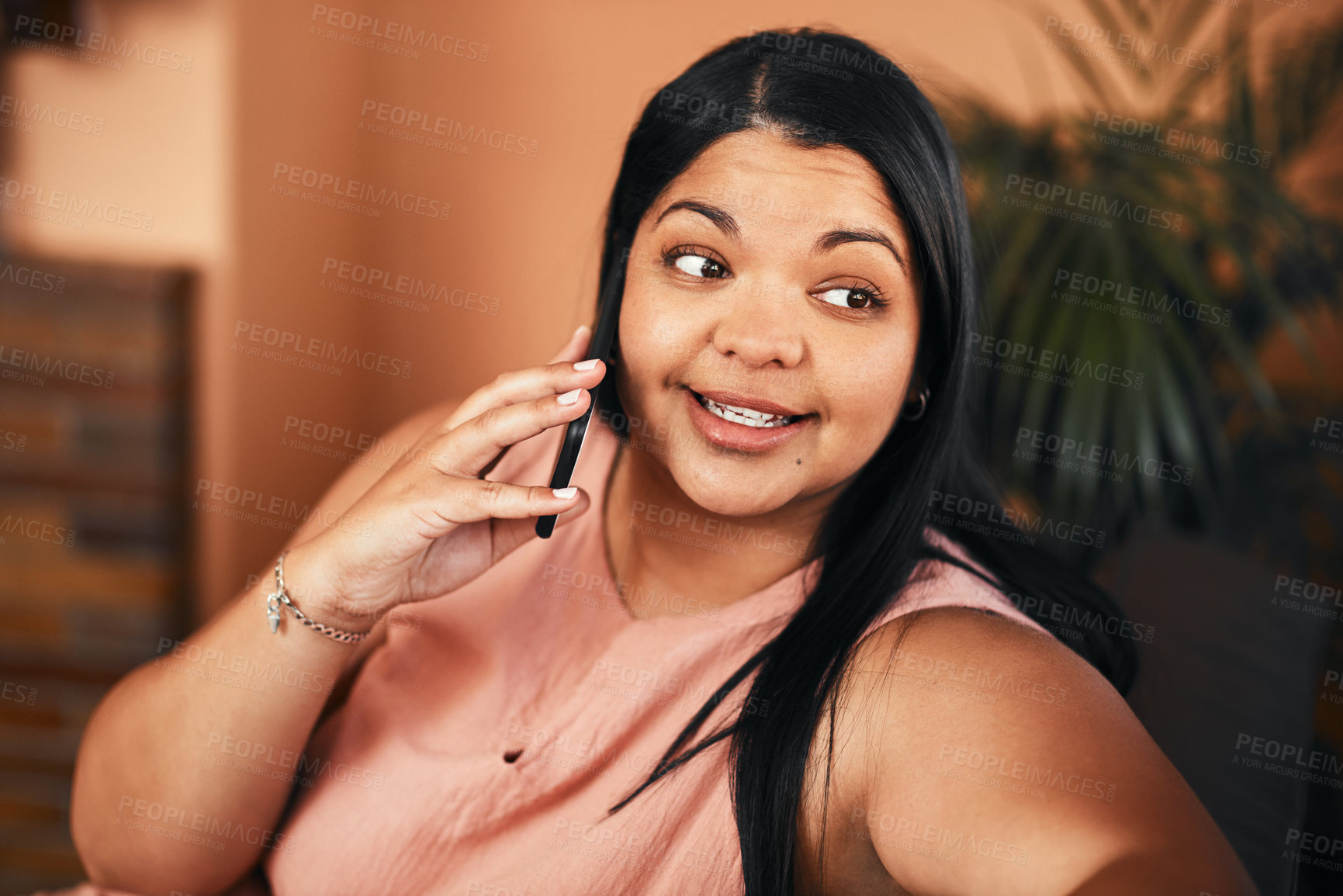 Buy stock photo Shot of a young woman talking on a cellphone at home