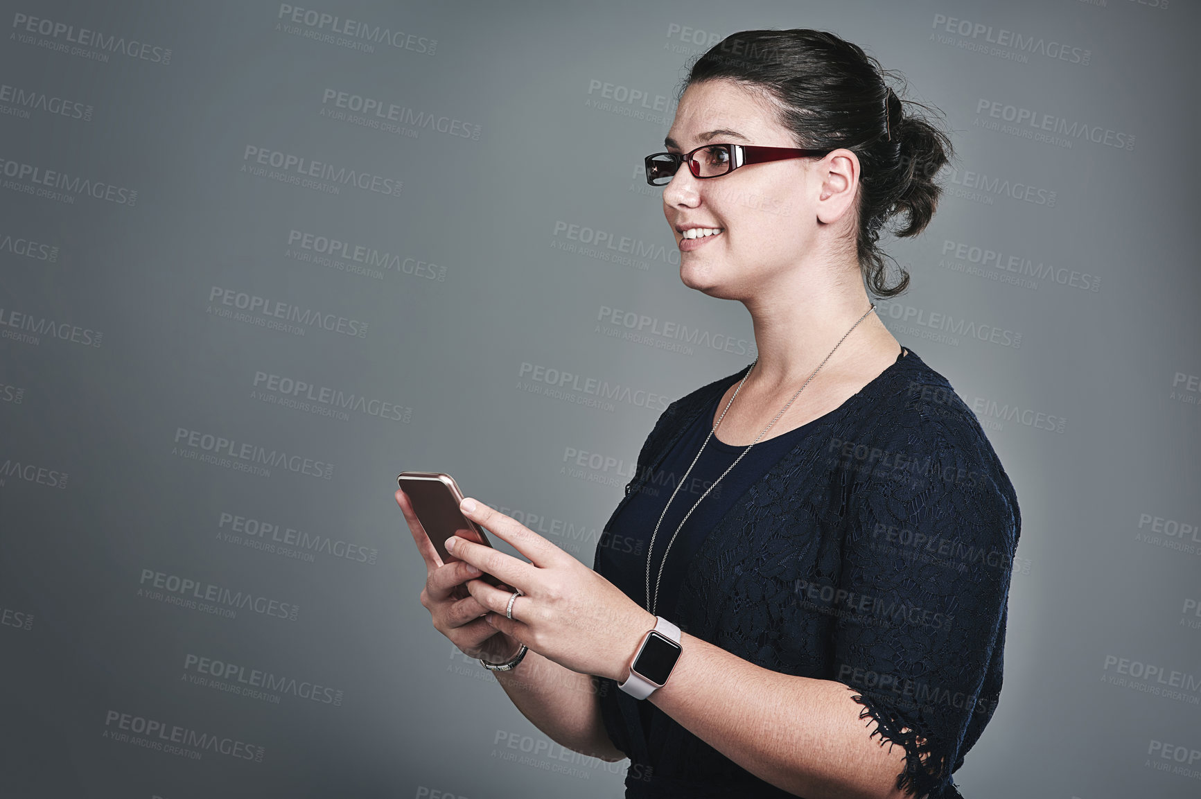 Buy stock photo Studio shot of a young businesswoman using a mobile phone against a grey background