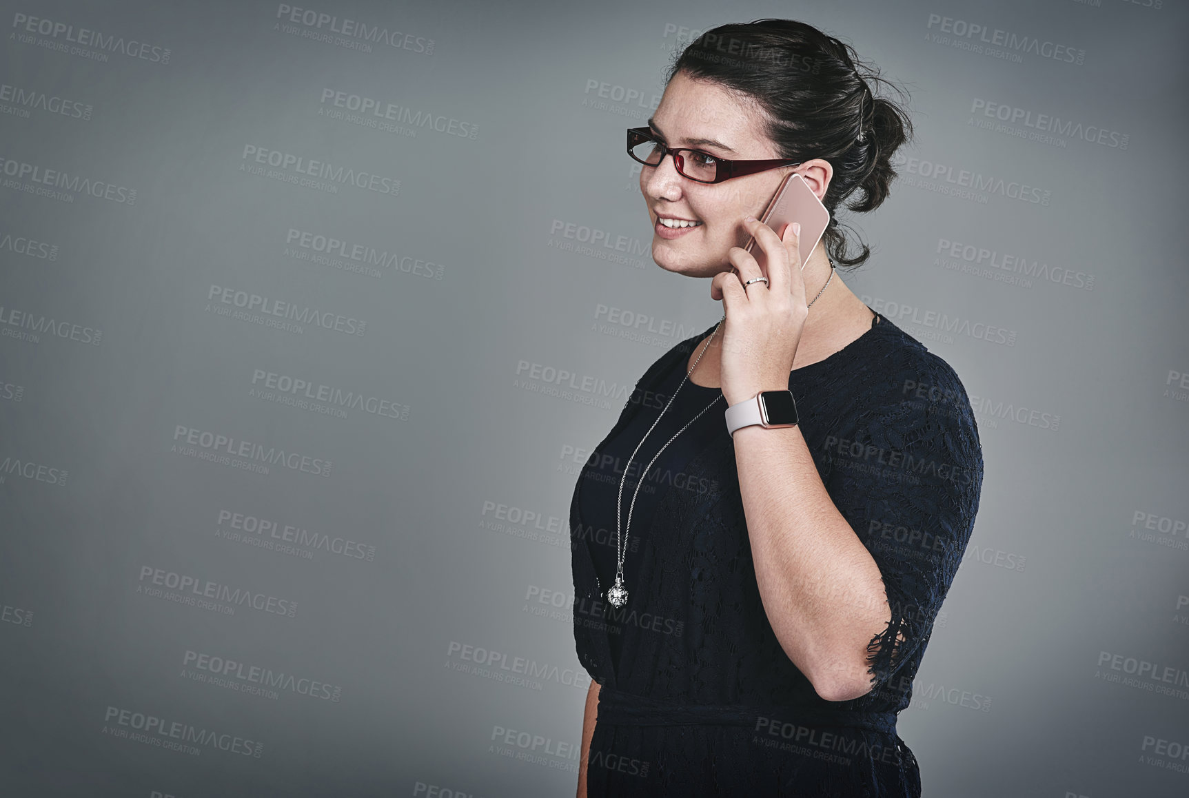 Buy stock photo Studio shot of a young businesswoman using a mobile phone against a grey background