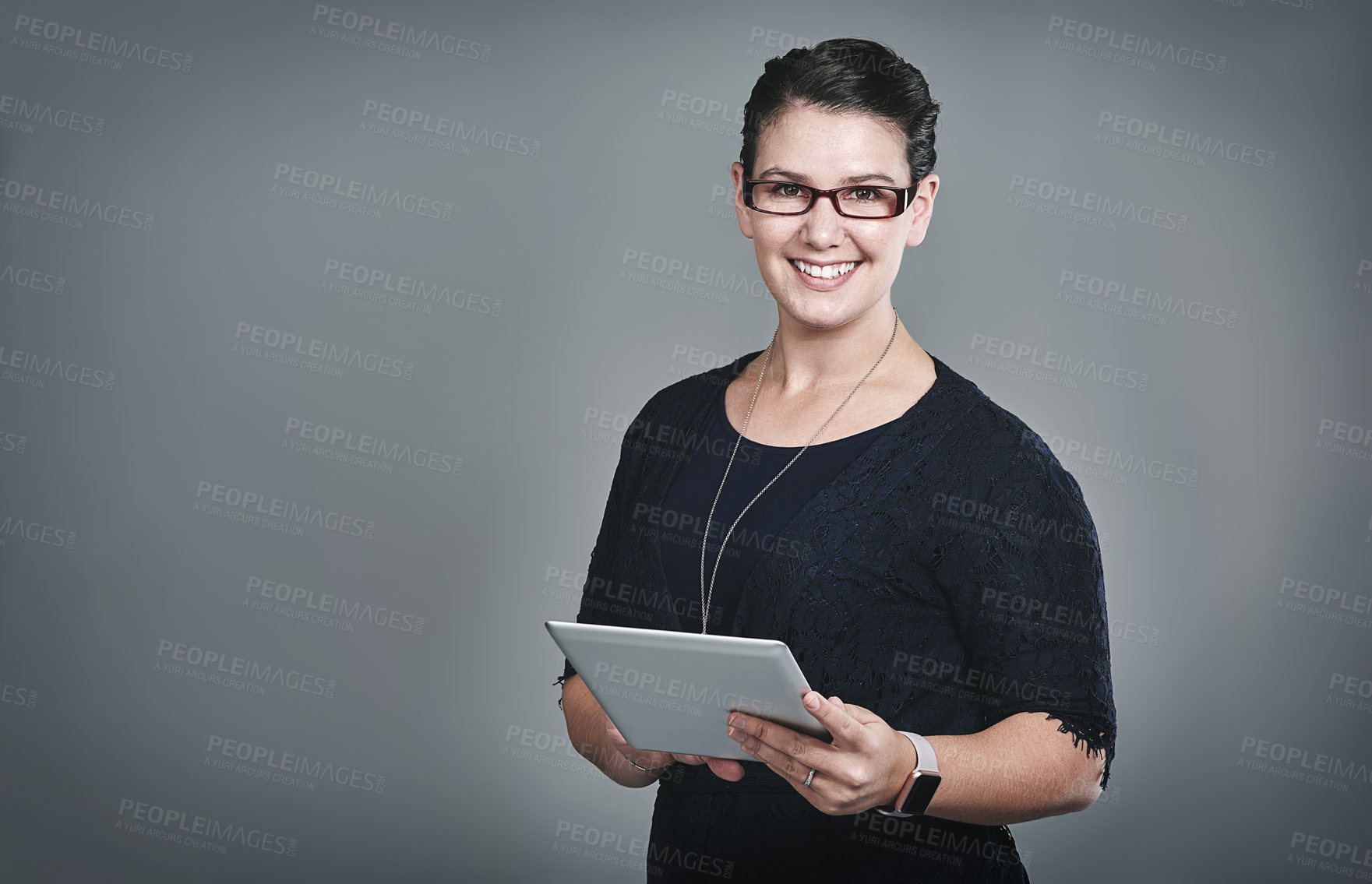 Buy stock photo Studio portrait of a young businesswoman using a digital tablet against a grey background