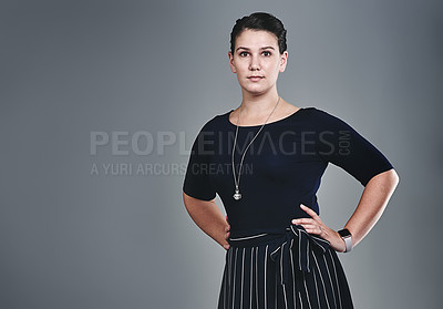 Buy stock photo Studio portrait of a confident young businesswoman posing against a grey background