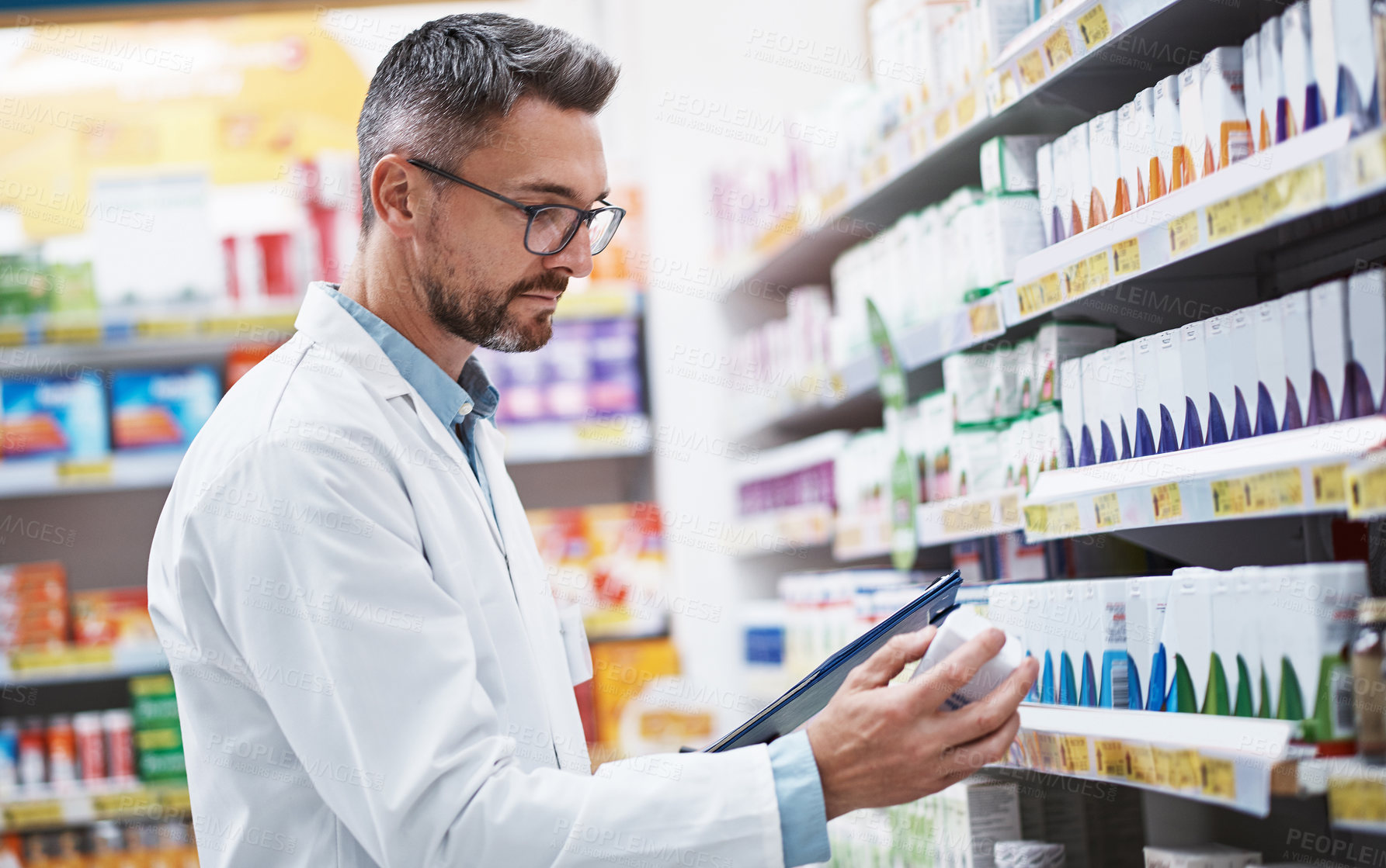 Buy stock photo Shot of a mature pharmacist doing inventory in a pharmacy