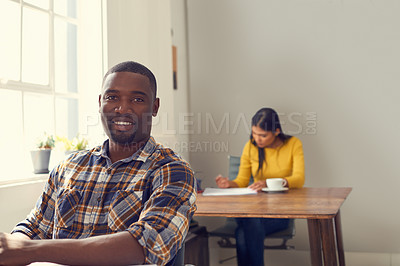 Buy stock photo Shot of a young businessman working at his desk in a modern office