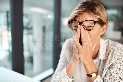 Buy stock photo Shot of a mature businesswoman looking stressed out while working in an office