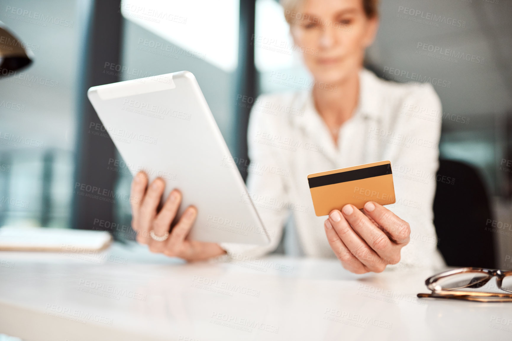 Buy stock photo Closeup shot of an unrecognisable businesswoman using a digital tablet and credit card in an office