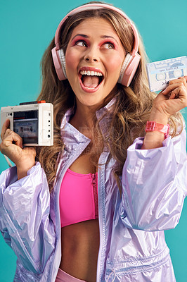 Buy stock photo Studio shot of a young woman holding a cassette player while dressed in 80s clothing