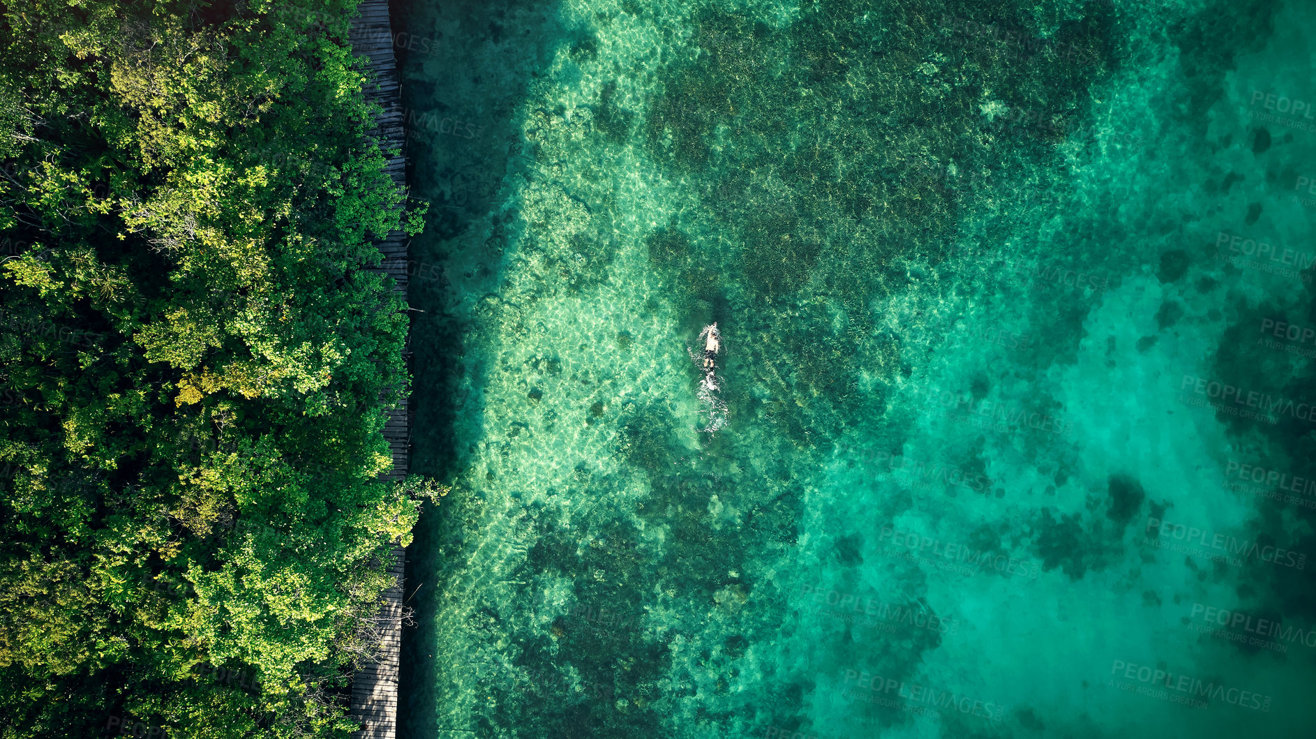 Buy stock photo High angle shot of an unrecognizable man swimming around the beautiful islands of Raja Ampat