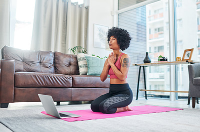 Buy stock photo Shot of a beautiful young woman using her laptop while practising yoga at home