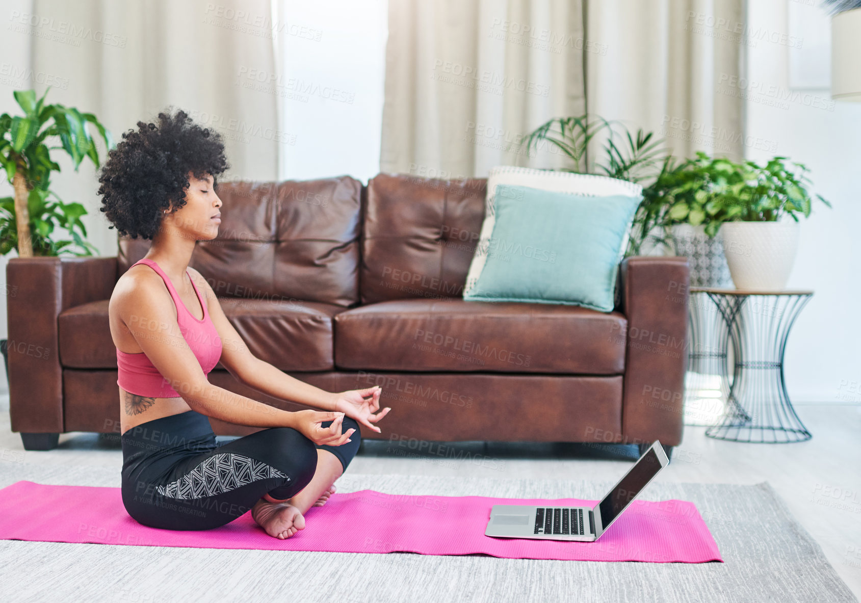 Buy stock photo Shot of a beautiful young woman using her laptop while practising yoga at home