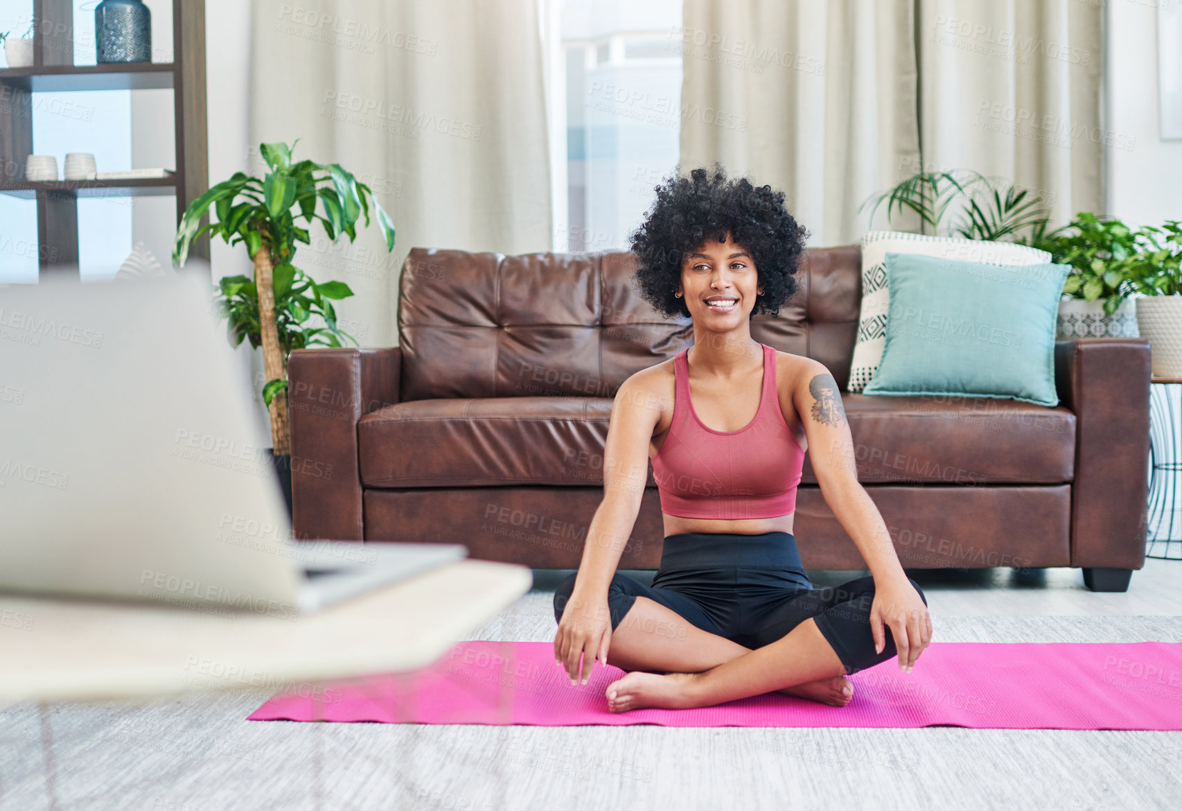 Buy stock photo Shot of a beautiful young woman looking at her laptop while practising yoga at home