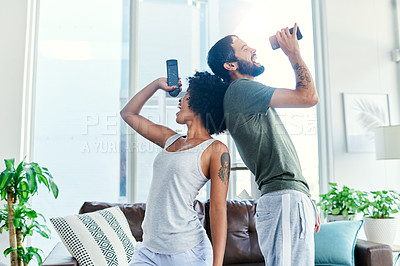 Buy stock photo Cropped shot of a couple having a sing along at home