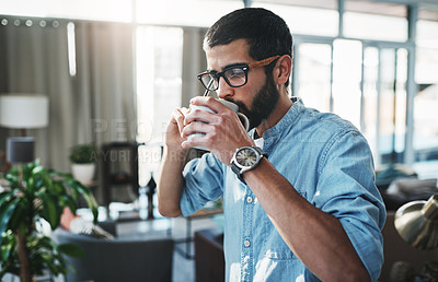 Buy stock photo Cropped shot of a handsome young man having coffee at home