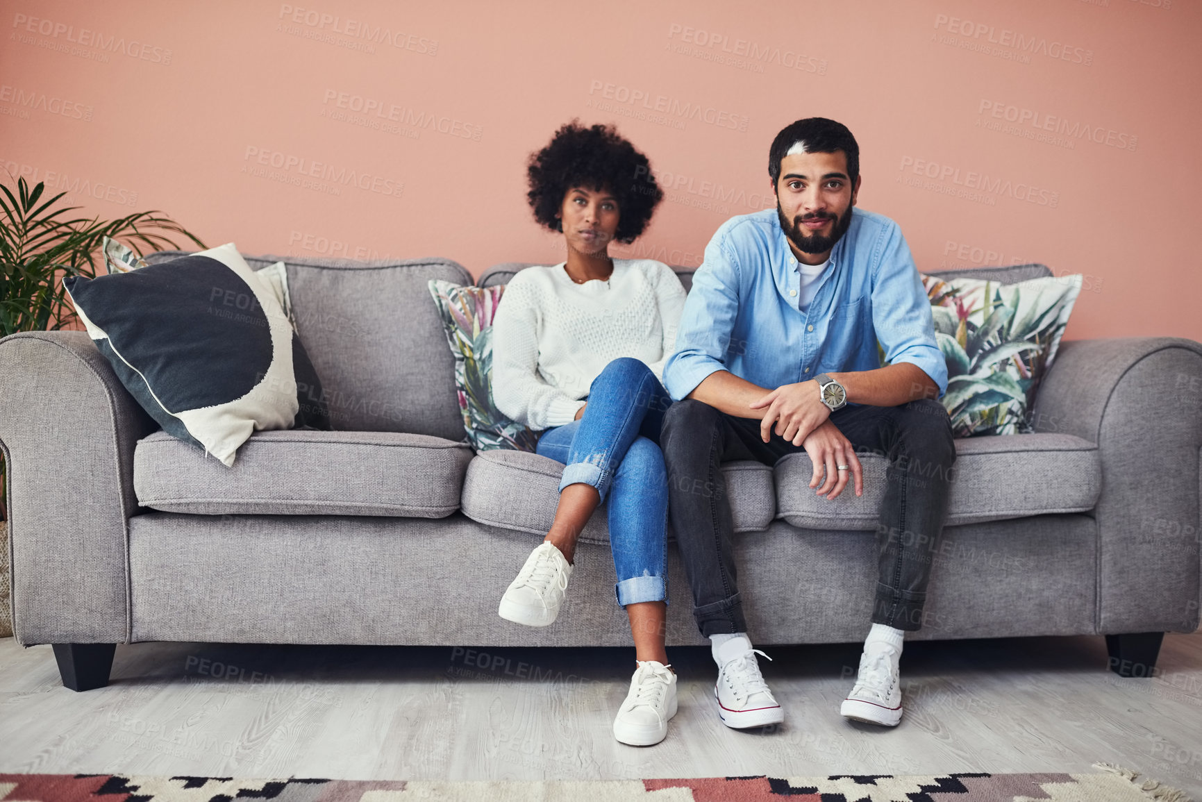 Buy stock photo Portrait of a young couple sitting on the sofa at home