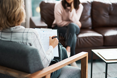 Buy stock photo Cropped shot of a psychologist writing notes during a therapeutic session with her patient