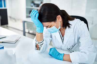 Buy stock photo Shot of a young scientist looking stressed out while working in a lab