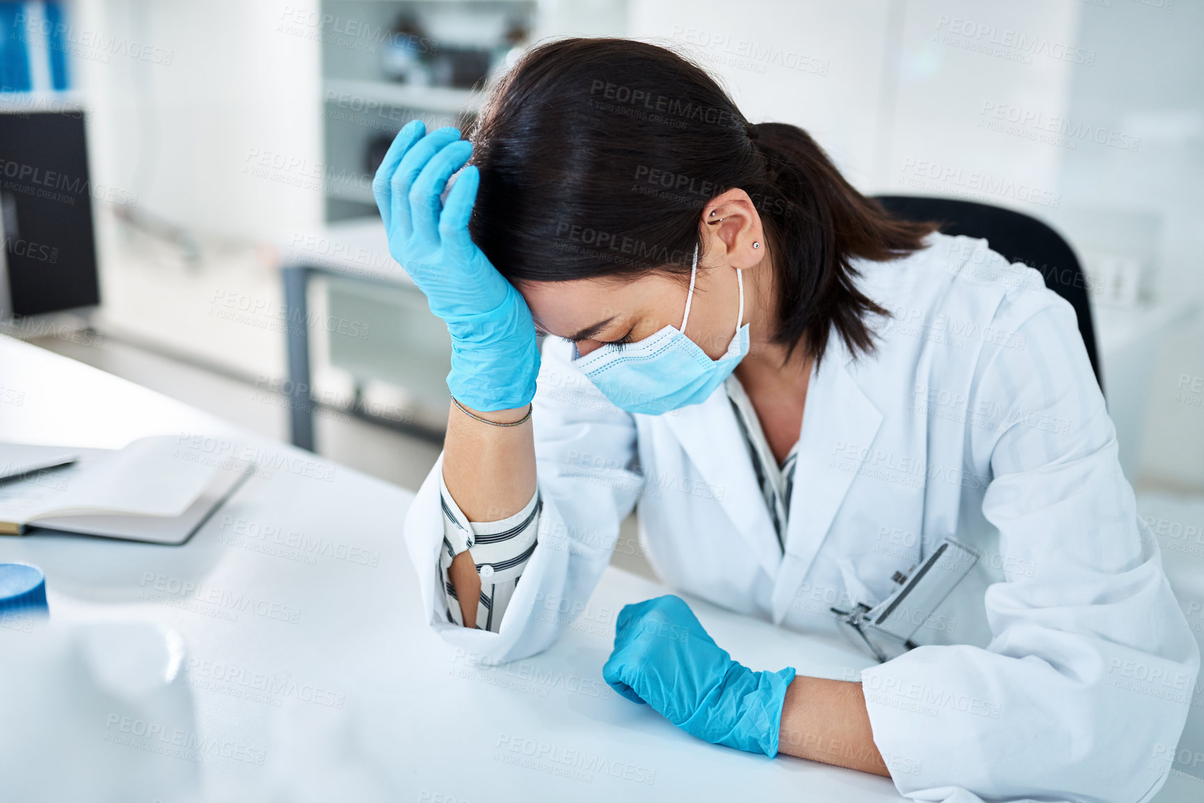 Buy stock photo Shot of a young scientist looking stressed out while working in a lab