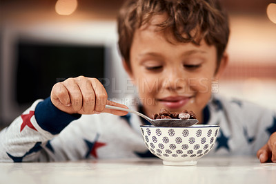 Buy stock photo Cropped shot of a young boy eating cereal at home