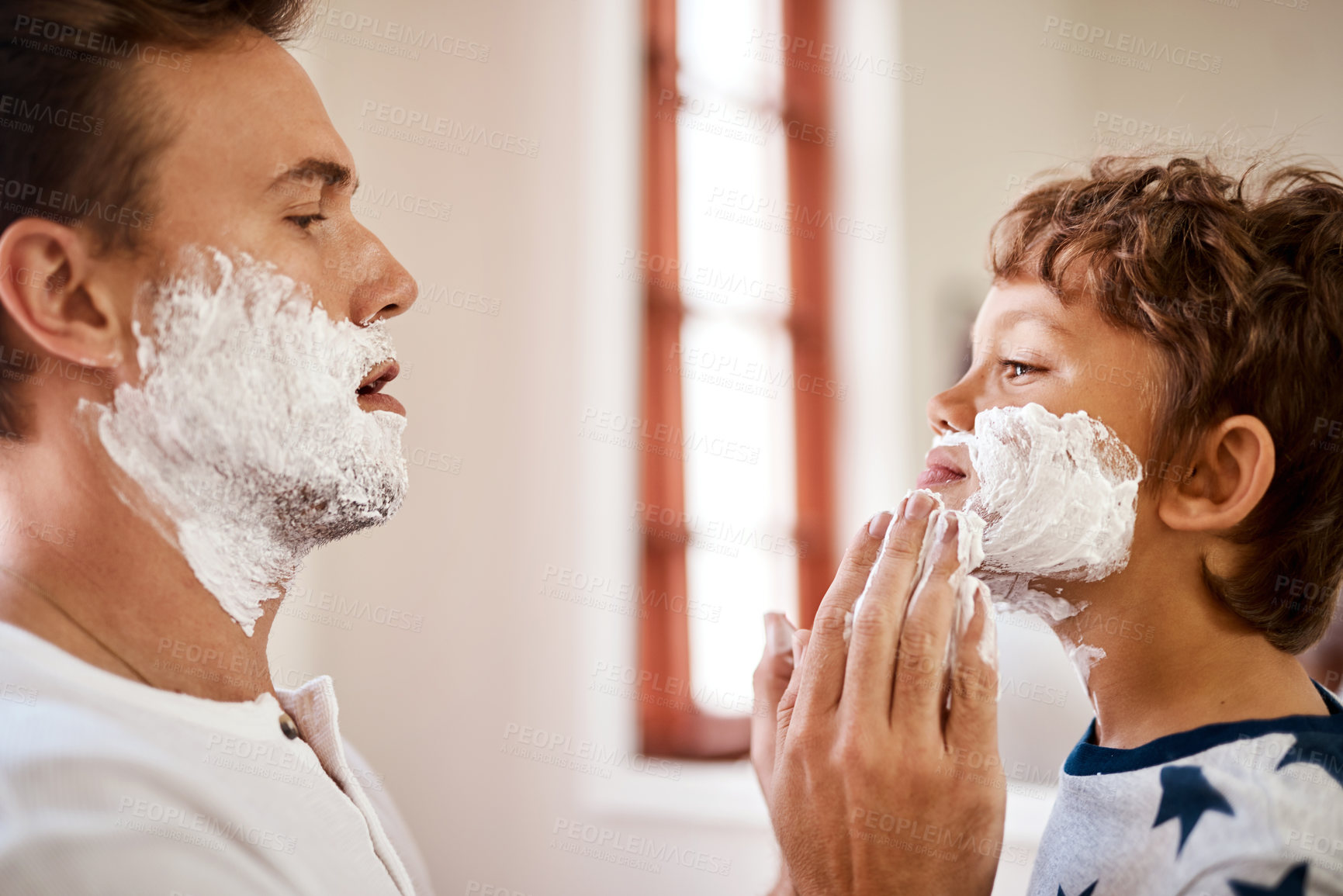 Buy stock photo Shot of a man teaching his young son how to shave at home