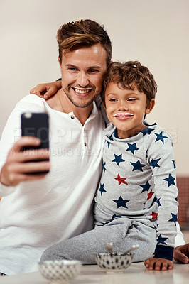 Buy stock photo Cropped shot of a young boy and his dad taking a selfie while having breakfast at home