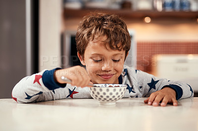 Buy stock photo Cropped shot of a young boy eating cereal at home
